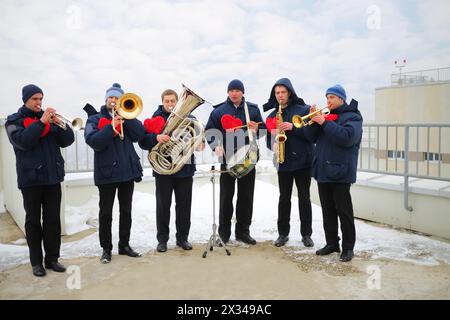 Brass band de six musiciens jouent sur le toit d'un grand bâtiment à l'hiver Banque D'Images