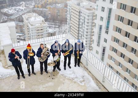 Brass band de six musiciens jouent sur le toit d'un grand bâtiment à l'hiver en Russie Banque D'Images