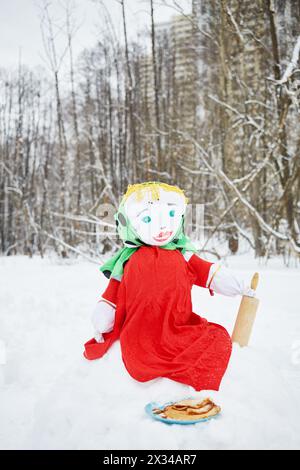Farci Masenitsa se trouve sur la banque de neige et assiette avec des crêpes dans le parc d'hiver. Banque D'Images