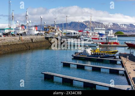 Reykjavik, Islande, 14.05.22. Bateaux touristiques colorés d'observation des baleines, côtes levées, bateaux de pêche et bateaux à moteur amarrés dans le port de Reykjavik avec Mount Esjan Mo Banque D'Images