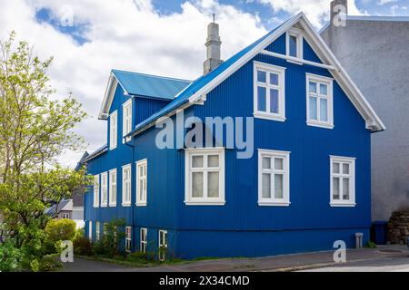 Maison résidentielle traditionnelle islandaise bleue avec toit à pignon, cadres de fenêtres blancs, revêtue de tôles ondulées à Reykjavik, Islande. Banque D'Images