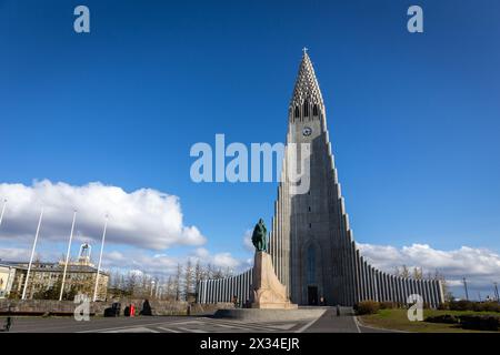 Reykjavik, Islande, 14.05.22. Hallgrimskirkja bâtiment de l'église moderniste avec la statue de Leif Erikson en face sur la colline Skolavorduholt, ciel bleu. Banque D'Images