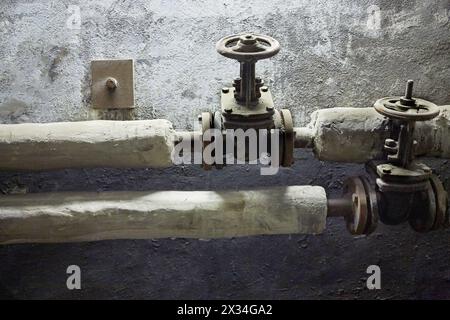 Tuyaux thermiquement isolés avec robinets-vannes dans le sous-sol du bâtiment. Banque D'Images