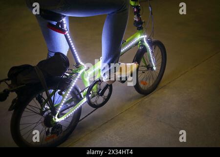 Vélo à pédales pour femmes avec rétroéclairage dans l'obscurité Banque D'Images