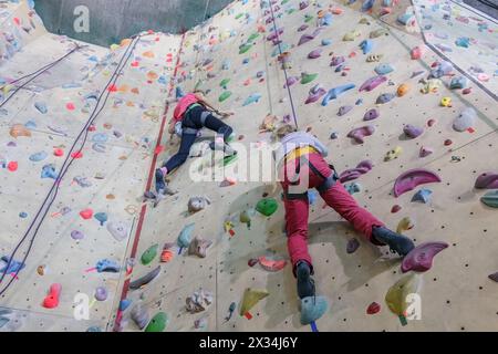 Escalade. Deux jeunes filles avec de l'équipement se lève sur un mur spécialement équipé pour les grimpeurs Banque D'Images