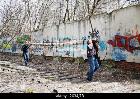 MOSCOU, RUSSIE - 18 avril 2015 : les gens portent un tronc d'arbre pendant les travaux de nettoyage au complexe résidentiel Elk Island. Plus de 2,5 millions de personnes participent Banque D'Images