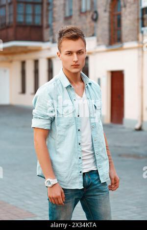 Beau jeune homme en vêtements denim dans la ville. Banque D'Images