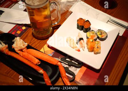Table avec crustacés et sushis sur assiettes, bière en verre, gros plan Banque D'Images