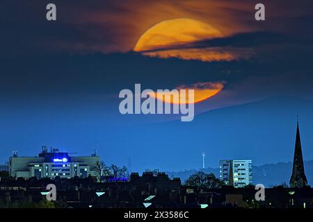 Glasgow, Écosse, Royaume-Uni. 24 avril 2024 : Météo britannique : pleine lune sur la colline de Tinto dans les frontières où les druides ont fait des sacrifices humains devant le Hilton et la flèche du théâtre Cotter dans le centre-ville, la pleine Lune d'avril ou la pleine Lune rose est connue sous différents noms tels que la Lune d'herbe germinante, la Lune grandissante et la Lune de poisson. Crédit Gerard Ferry/Alamy Live News Banque D'Images