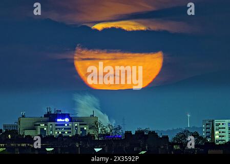 Glasgow, Écosse, Royaume-Uni. 24 avril 2024 : Météo britannique : pleine lune sur la colline de Tinto dans les frontières où les druides ont fait des sacrifices humains devant le Hilton et la fumée de la distillerie de whisky gorbals dans le centre-ville, la pleine Lune d'avril ou la pleine Lune rose est connue sous différents noms tels que la Lune d'herbe germinante, la Lune grandissante et la Lune de poisson. Crédit Gerard Ferry/Alamy Live News Banque D'Images