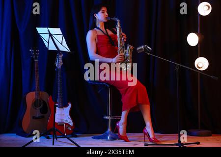 Belle femme jouant du saxophone sur scène Banque D'Images