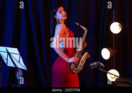 Belle femme avec saxophone sur scène Banque D'Images