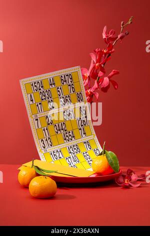 Un plat avec enveloppe, mandarine et carte de bingo. Selon le calendrier solaire, le nouvel an chinois tombe des jours différents Banque D'Images