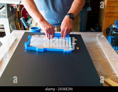 Application de peintres bleus pour construire un barrage pour empêcher l'époxy de se déverser sur les bords et de couvrir la zone où l'époxy n'est pas voulu. Cary, Caroline du Nord Banque D'Images