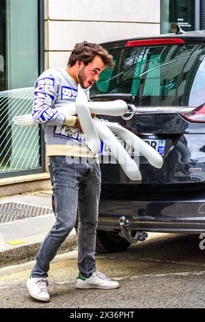 Jeune homme (commerçant) luttant pour charger quatre mannequins mannequins dans sa voiture - Tours, Indre-et-Loire (37), France. Banque D'Images