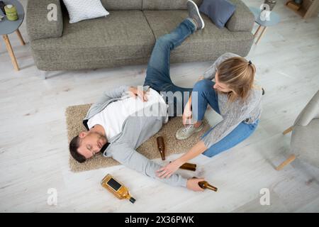 femme trouvant un homme inconscient sur le sol après avoir bu Banque D'Images