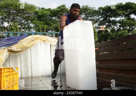 Dhaka. 25 avril 2024. Un travailleur décharge un bloc de glace d’un camion au milieu de la vague de chaleur en cours à Dhaka, au Bangladesh, le 23 avril 2024. Crédit : Xinhua/Alamy Live News Banque D'Images