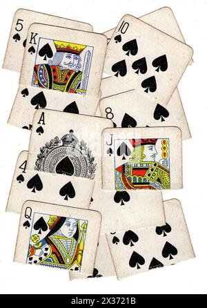 Un montage de pique vintage jouant aux cartes déchirées en deux sur un fond blanc. Banque D'Images