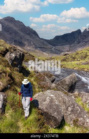 Seule femme hill-walker en ordre décroissant de la corrie de Coire Lagan dans les montagnes Cuillin noires, Isle of Skye, Scotland, UK Banque D'Images