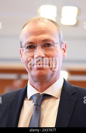 Karlsruhe, Allemagne. 25 avril 2024. Jürgen Paepke, directeur juridique de la Ligue allemande de football (DFL), attend devant la Cour constitutionnelle fédérale le début de l'audience sur la question de savoir si la Ligue allemande de football (DFL) peut être facturée pour les frais de police pour les matchs à haut risque. Crédit : Uli Deck/dpa/Alamy Live News Banque D'Images