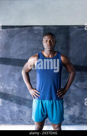 Athlète afro-américain confiant et modèle de fitness se tient dans le gymnase, les mains sur les hanches Banque D'Images