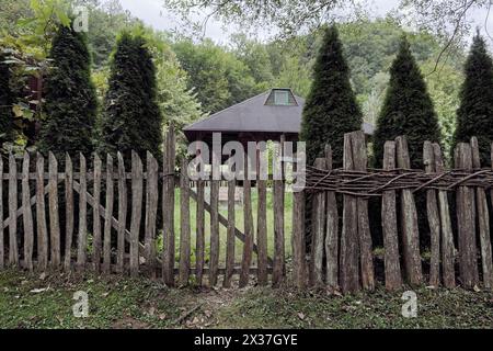 Maison avec petite porte en bois et haie le long du sentier menant à la source de la rivière Gradac, Serbie Banque D'Images