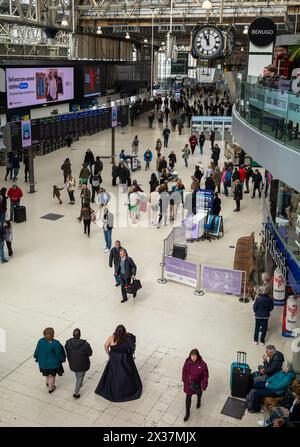 Passagers sous la célèbre horloge sur le hall principal de la gare de Waterloo à Londres, Royaume-Uni. Banque D'Images