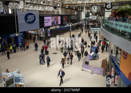 Passagers sous la célèbre horloge sur le hall principal de la gare de Waterloo à Londres, Royaume-Uni. Banque D'Images