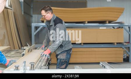 Menuisier masculin senior avec des lunettes travaillant dans son atelier. Photo de haute qualité Banque D'Images