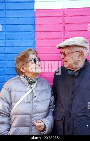 Un couple plus âgé se tient à côté de l'autre, souriant et portant des lunettes de soleil. la communication dans la famille Banque D'Images