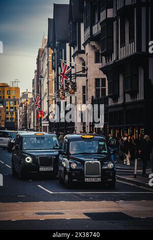 Londres, Royaume-Uni - janvier 2024 : deux taxis emblématiques dans les rues de Londres Banque D'Images