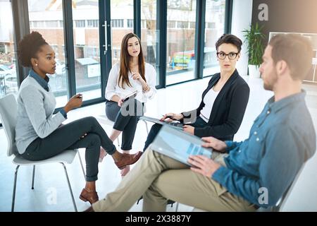 Gens d'affaires, documents et réunion au bureau pour le brainstorming, la collaboration et la conversation. Collègues parlant ou communiquant sur le lieu de travail Banque D'Images