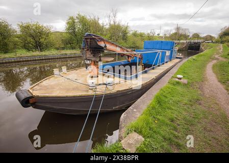 Bateau de maintenance équipé d'une grue (Atlas 3008) et d'une zone de carrosserie profonde et vide où les dépôts peuvent être sécurisés Leeds et Liverpool canal près de Gargrave, Banque D'Images