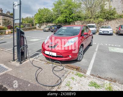 Recharge électrique en cours au parking Gargrave (Yorkshire du Nord). Où plusieurs points de recharge sont en place Banque D'Images