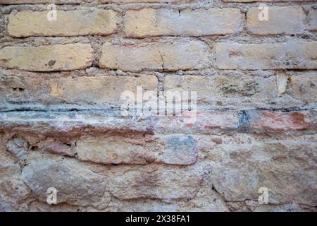 Le mur de pierre structurelle gris de l'ancien bâtiment se compose de vieilles briques sombres. Fond structurel de la nature. Banque D'Images