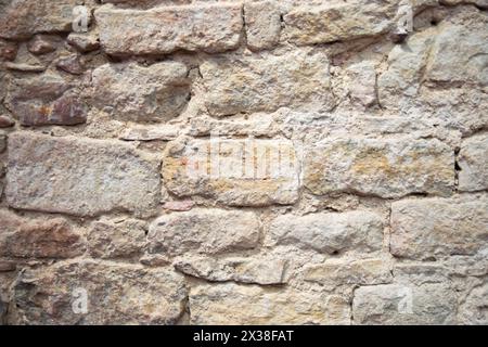 Le mur de pierre structurelle gris de l'ancien bâtiment se compose de vieilles briques sombres. Fond structurel de la nature. Banque D'Images