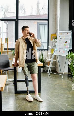 Un bel homme d'affaires avec une jambe cassée est assis sur une chaise dans un bureau. Banque D'Images