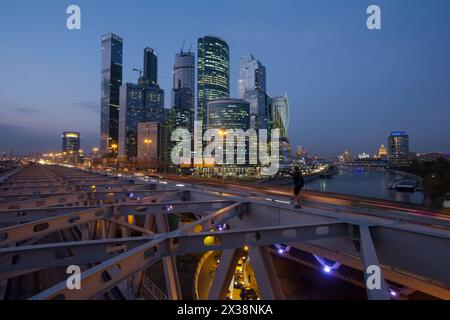 MOSCOU - 18 septembre 2015 : L'homme se tient sur le pont de chemin de fer et tire le centre d'affaires international de Moscou et le quai dans la soirée. Investissements à Moscou Interna Banque D'Images