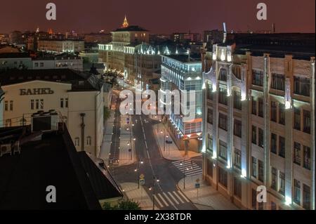 Rue Pyatnitskaya avec route, pistes cyclables et trottoirs la nuit à Moscou. Texte sur le mur - banque Banque D'Images