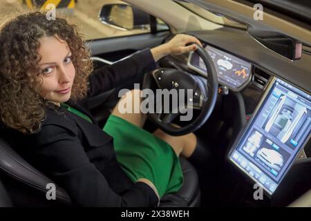 MOSCOU, RUSSIE - 11 nov 2015 : Smiling Woman (avec autorisation du modèle) est assis dans la Tesla S car. L'écran tactile de 17 pouces de la Model S contrôle la plupart du fu de la voiture Banque D'Images