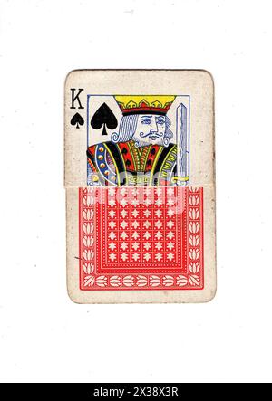 Un roi déchiré de pique carte à jouer vintage montrant l'avant et l'arrière sur un fond blanc. Banque D'Images