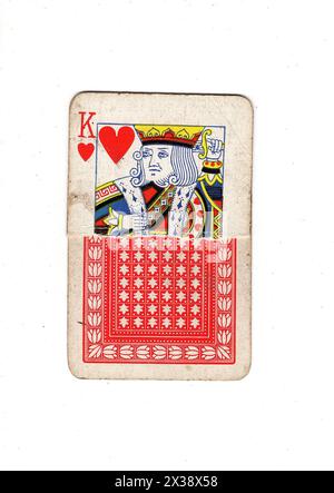 Une carte à jouer vintage roi des coeurs déchiré montrant le devant et le dos sur un fond blanc. Banque D'Images
