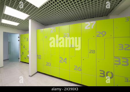 Vestiaire moderne lumineux vide dans la salle de sport avec de nombreux casiers verts Banque D'Images