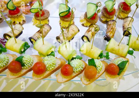 Différents canapés - hors-d'œuvre froids sont sur la table avec un tissu blanc Banque D'Images