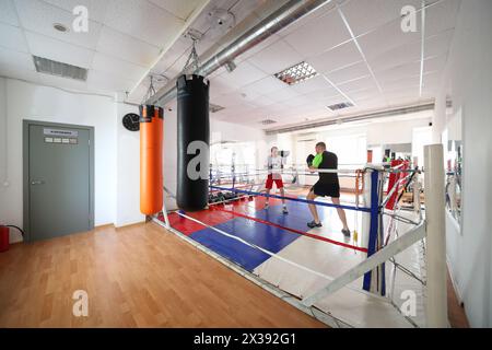 Deux hommes se battent dans la salle de gym moderne Nouveau Sparta avec anneau de boxe, en plus de l'ensemble standard de services de fitness Nouveau Sparta offre des cours avec champion - Hig Banque D'Images