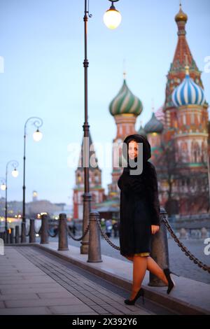 Jolie femme en manteau de fourrure de vison pose près de finis Basil Cathedral à Moscou Banque D'Images