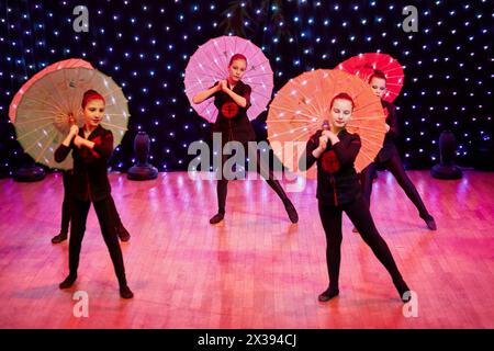 Cinq filles avec des parapluies exécutent la danse dans le style chinois lors du concert du studio de danse Banque D'Images