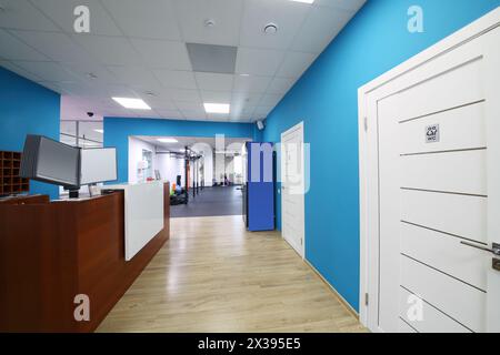 Réception avec comptoir en bois et murs bleus dans un centre de fitness vide Banque D'Images