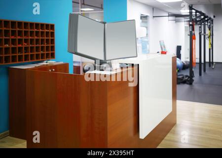 Réception élégante avec comptoir en bois et murs bleus dans le centre de remise en forme Banque D'Images