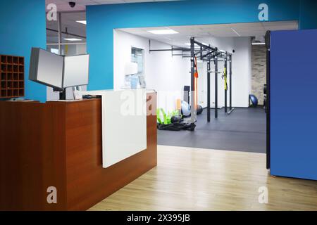 Réception élégante vide avec comptoir en bois et murs bleus dans le centre de remise en forme Banque D'Images